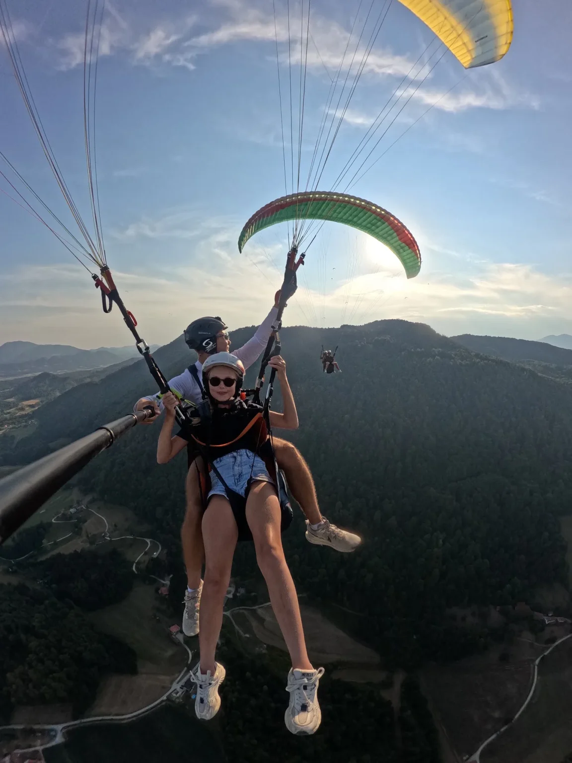 Tandemski polet z drugim jadralnim padalom v ozadju